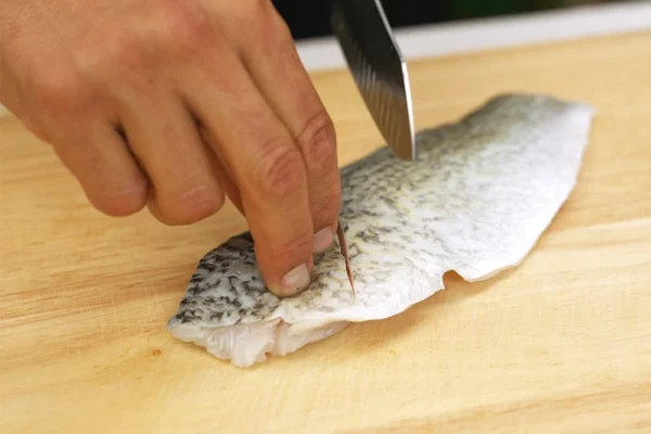 Barramundi-Fillets-Cooked A chef scores a barramundi fillet