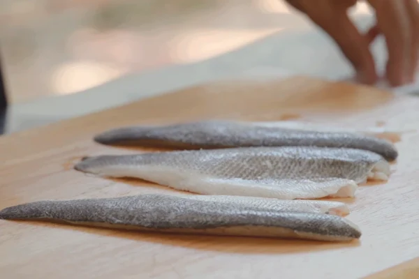Branzino-Fillets-Grilled Branzino fillets on a cutting board to be seasoned