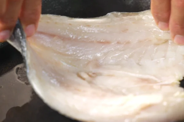 Butterflied-Branzino-Cooked A butterflied branzino is placed in a pan to cook