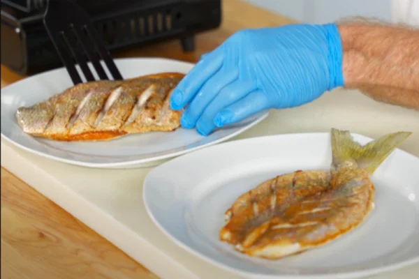 Butterflied-Yellowtail-Fillet-Plate-Comparison A chef plates a natural cut yellowtail snapper fillet next to a butterflied yellowtail snapper fillet to compare