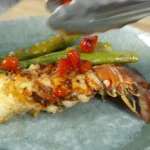 A poached lobster tail with asparagus and tomatoes