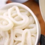 Raw calamari rings in a bowl before being breaded