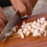 A chef chops raw conch meat