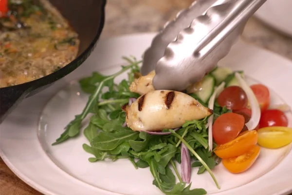 Squid-Tubes-Plated-Arugula Grilled and stuffed calamari tubes are plated over a bed of arugula