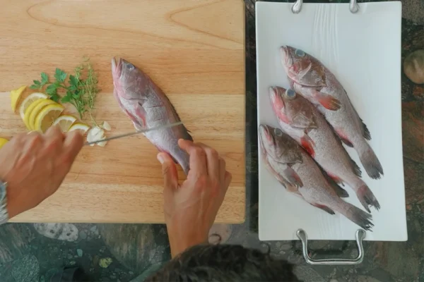 Whole-Grouper A chef scores a whole grouper on a cutting board