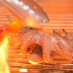 A whole octopus is grilled over fire