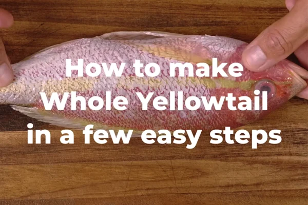 Whole-Yellowtail-Cooked A chef holds a whole yellowtail snapper with the text "How to make Whole Yellowtail in a few easy steps"