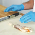 A piece of conch meat on a cutting board